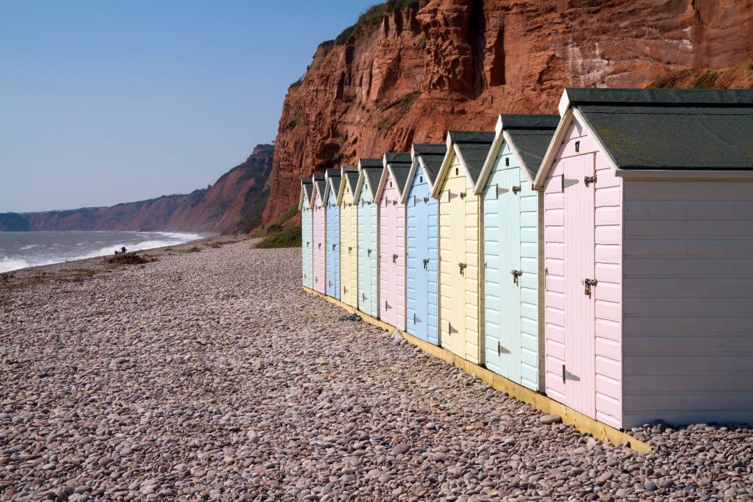 Colourful Beach Huts With A Pebble Beach